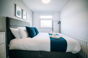 a bedroom with a large bed with blue and white pillows at Freda House By Horizon Stays in Sunderland +30 photos