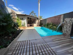 a swimming pool in front of a house at Casa Luz - triplex com piscina in Foz do Iguaçu