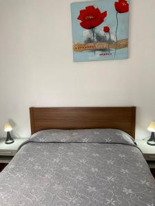 a bedroom with a bed with a painting on the wall at Casa Armonía del sol in San Bartolomé de Tirajana