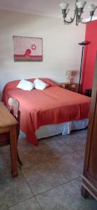 a bedroom with a bed with a red blanket at Habitación de huéspedes con entrada independiente in Concordia