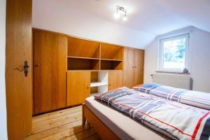 a bedroom with a bed with wooden cabinets and a window at Ferienwohnung Alstaden in Oberhausen