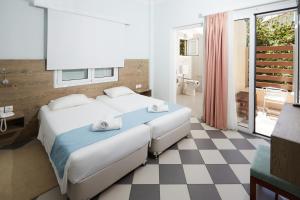 a bedroom with a bed and a checkered floor at Klonos Anna in Egina