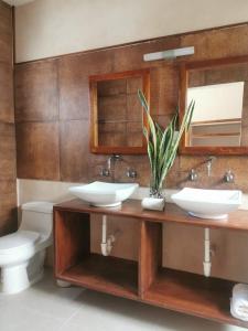 a bathroom with two sinks and a toilet at Casa Tolok in Mérida