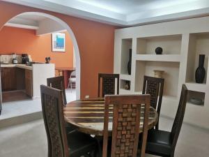 a dining room with a wooden table and chairs at Casa Tolok in Mérida