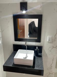 uma casa de banho com um lavatório e um espelho em RM hospedagem em Cabo Frio