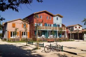 een fiets geparkeerd voor een gebouw bij Appartement avec piscine sur le Bassin d'Arcachon in Le Teich