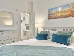 a bedroom with a large bed with blue pillows at Lundy Lookout 5 minutes drive to beach Hot tub in Westward Ho