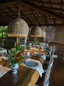 een lange houten tafel met stoelen en efficiënte efficiënte efficiënte efficiënte efficiënte efficiënte efficiënte efficiënte efficiënte efficiënte bij Locanda Ariramba in Santa Cruz Cabrália