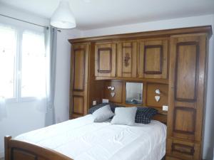 ein Schlafzimmer mit einem großen Bett mit Holzschränken in der Unterkunft Gite de la Vallée de Mai in Audignicourt
