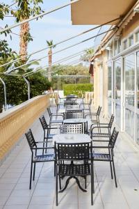 a row of tables and chairs on a patio at Klonos Anna in Egina