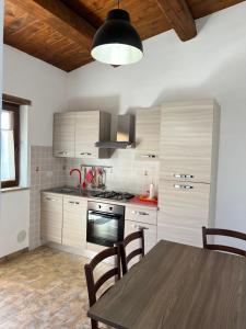 cocina con mesa y fogones horno superior en Agriturismo Tre Monti en Meggiano