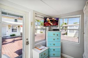 Habitación con vestidor, TV y ventanas. en C2-Seahorse en St Pete Beach