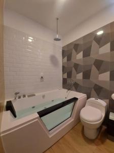 a bathroom with a bath tub and a toilet at Hostal Atenea in Ilo