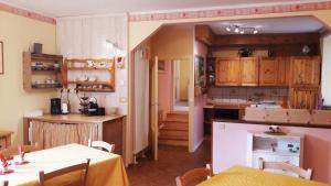 a kitchen with wooden cabinets and a table with two tables at B&B Al Larice in Strigno