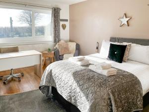 een slaapkamer met een bed, een bureau en een tafel bij Gretna - Uk41823 in Longnor
