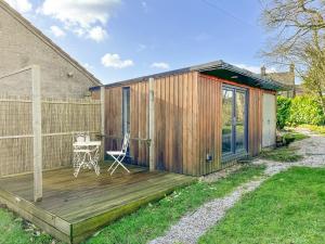 een houten terras met een stoel op een huis bij Gretna - Uk41823 in Longnor