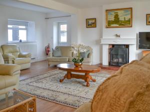 a living room with a coffee table and a fireplace at Springdale Farmhouse in North Burton