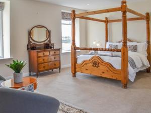 um quarto com uma cama de madeira e um espelho em Springdale Farmhouse em North Burton