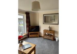 a living room with a television and a table at The Waverley Inn Holiday Homes in Inverness