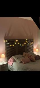 Un dormitorio con una cama grande con luces. en Le Kerioubet - B&B au cœur du Pays d’Auge, en Saint-Martin-de-la-Lieue