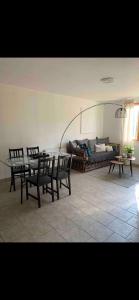 a living room with a table and chairs and a couch at Le Kerioubet - B&B au cœur du Pays d’Auge in Saint-Martin-de-la-Lieue