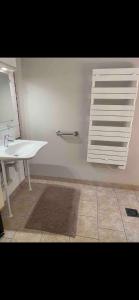 a bathroom with a white sink and a white shelf at Le Kerioubet - B&B au cœur du Pays d’Auge in Saint-Martin-de-la-Lieue