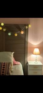 a bedroom with a bed and a lamp on a night stand at Le Kerioubet - B&B au cœur du Pays d’Auge in Saint-Martin-de-la-Lieue