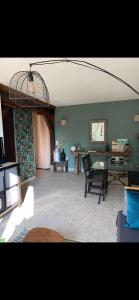 ein Wohnzimmer mit einem Tisch und einem Stuhl in der Unterkunft Le Kerioubet - B&B au cœur du Pays d’Auge in Saint-Martin-de-la-Lieue