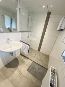 a bathroom with a sink and a shower at Ferienwohnungen Zur Abtei Bodenseeregion in Ravensburg