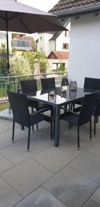 a table and chairs on a patio with an umbrella at Ferienwohnungen Zur Abtei Bodenseeregion in Ravensburg