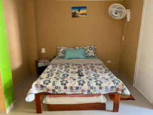 a bedroom with a bed in a room with a fan at LodgeFabi'sPlace in San Andrés