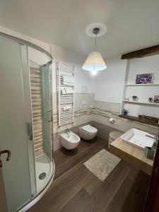 ein Badezimmer mit 2 Waschbecken, einer Dusche und 2 WCs in der Unterkunft B&B La Dolce Sosta in Fonni