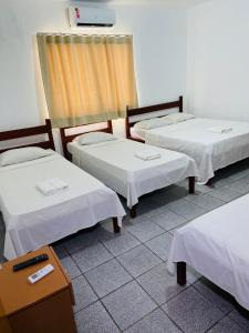 a group of three beds in a room at Granvalle Hotel Juazeiro in Juazeiro