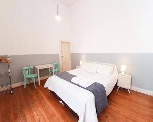 LOPEZ Hostel & Suites في بوينس آيرس: غرفة نوم بسرير وطاولة وكراسي