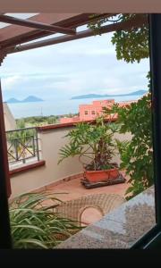 a view from the balcony of a house with a plant at "Appartamento del Mare Gliaca" con vista Isole Eolie,ampia terrazza,wifi e parcheggio gratuito in Piraino