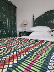 a bed with a colorful blanket on top of it at Mont' Sobro House Rooms in Évora
