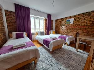 a bedroom with two beds and a brick wall at Hotel Good Night in Jalal-Abad
