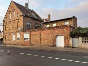 a brick building with a white door on a street at Apartment NV in Lutherstadt Eisleben