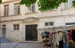 a market stand in front of a building with clothes at Appart Exceptionnel place du Palais des papes Wifi climatisation in Avignon