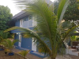 uma casa azul com uma palmeira em frente em LodgeFabi'sPlace em San Andrés