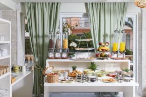 a buffet of food on a white table with green curtains at Klonos Anna in Egina