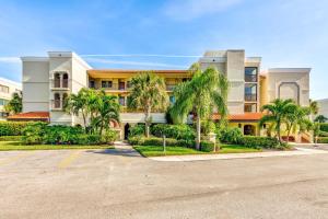 a building with palm trees in front of a parking lot at Land's End 8-401 Beach Front in St Pete Beach