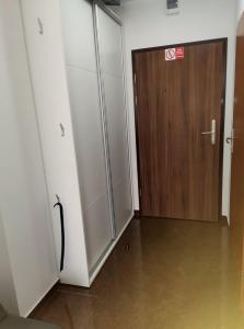 a room with a sliding door and a wooden door at Apartament Planeta 110 Mielno in Mielno