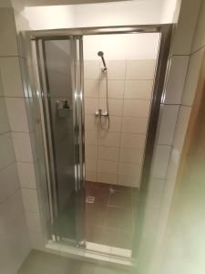 a shower with a glass door in a bathroom at Apartament Planeta 110 Mielno in Mielno