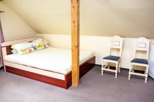 a bedroom with a bunk bed and two chairs at Mingės Egzotika in Mingė