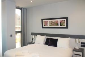 um quarto com uma cama branca e uma janela em Apartamento - Riba De Sella em Ribadesella
