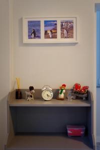 een plank met een klok en andere voorwerpen erop bij Casa Emon Cascais New Mordern Apartment Two Bedrooms in Cascais
