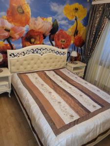 Ulbrokas Apartment في ريغا: غرفة نوم مع سرير مع زهور على الحائط