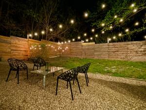 two chairs and a table in a backyard at night at Downtown Views, Rooftop Deck, Pets in Dallas