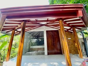 een houten ingang naar een huis met een rood dak bij Sindu Grand Cabana Bentota in Bentota